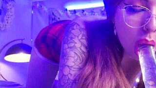 Dorm Tart with glasses is sucking a transparent dildo.
